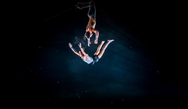 un homme et une femme en train de faire une acrobatie sur un trapèze